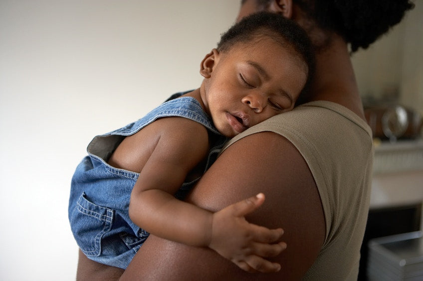 baby boy sleeping on mother's shoulders