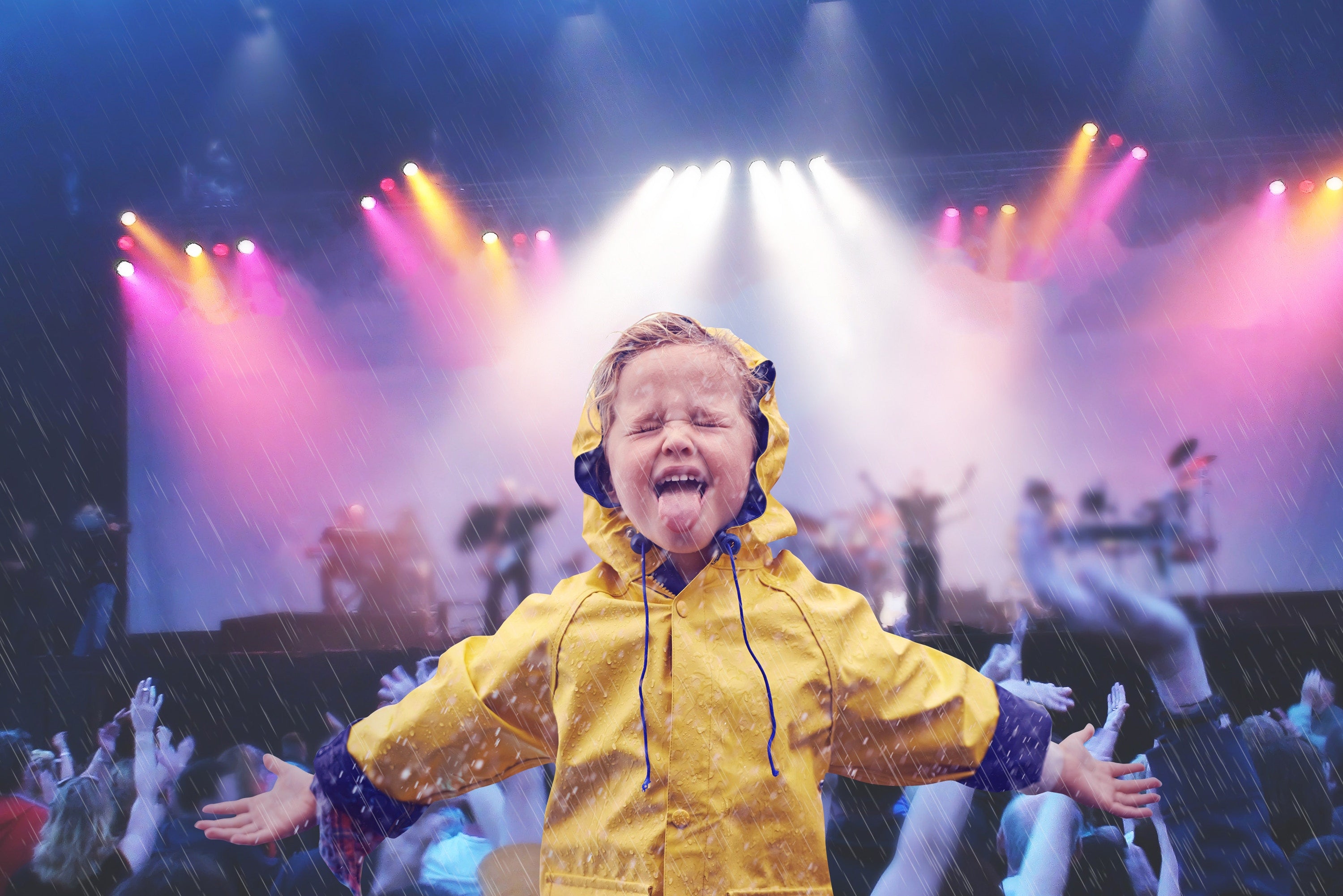 Cheerful boy wearing raincoat enjoying in rain at music concert