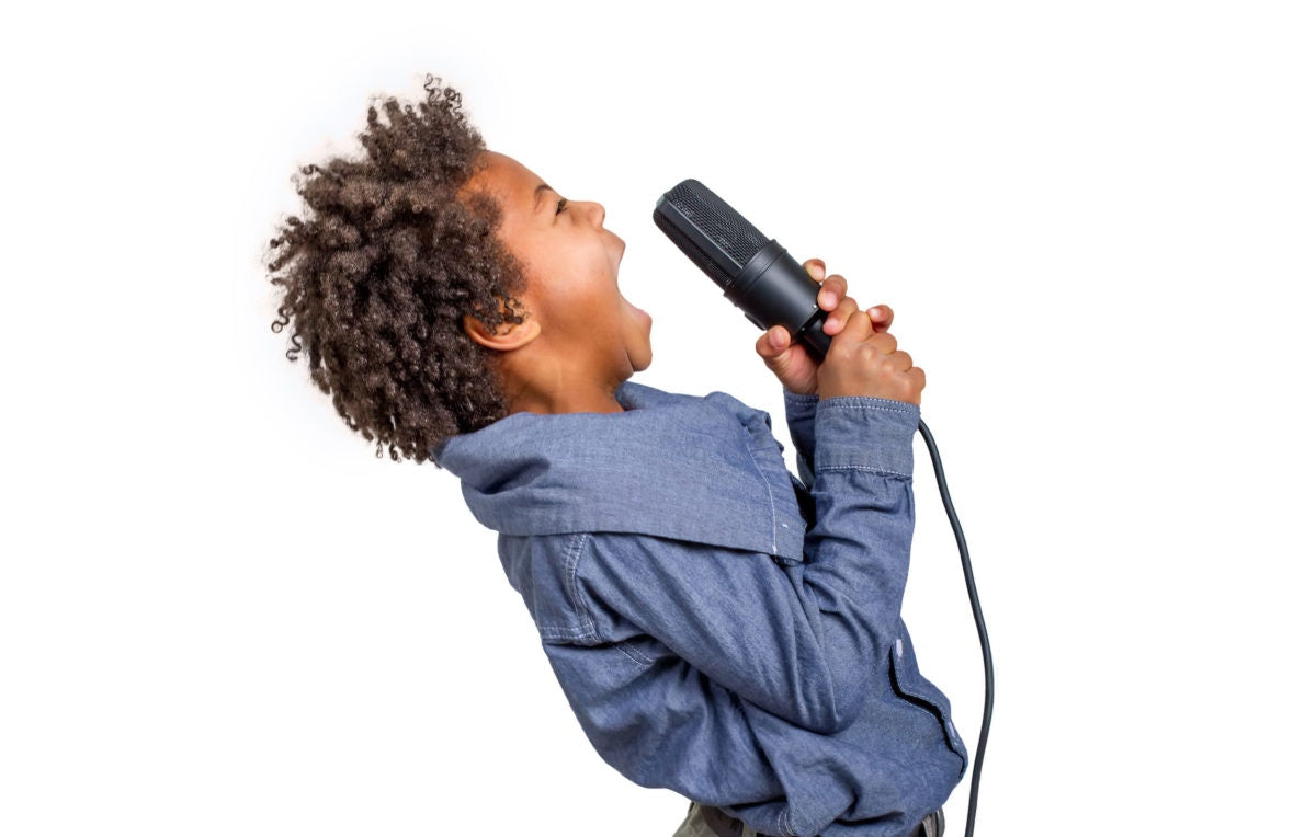 A kid singing a song holding a microphone