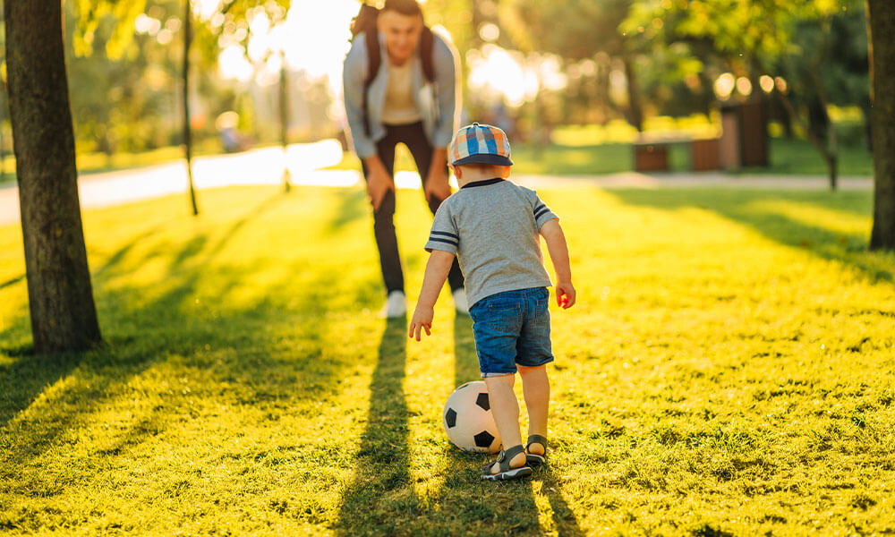 father and son playing soccer