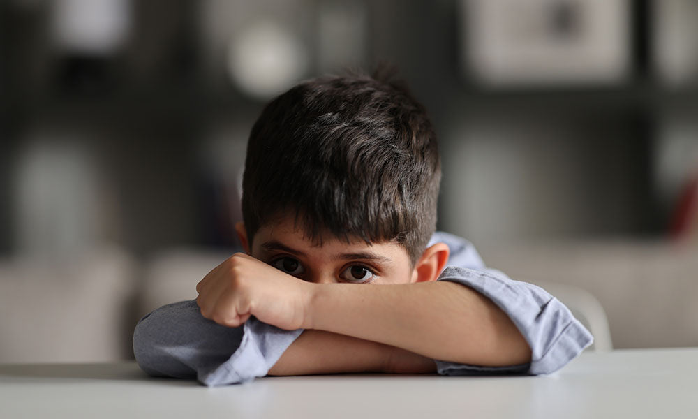 boy with his eyes open on desk