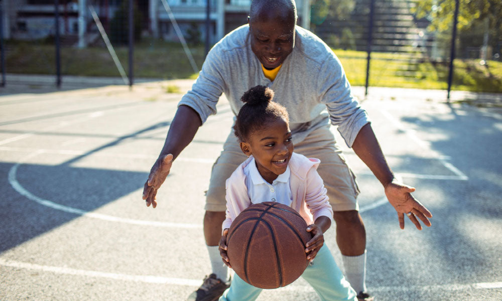 father playing basketball with daughter