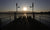 friends sitting on wooden dock during sunset