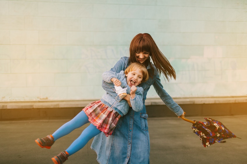 a little girl playing with her mother