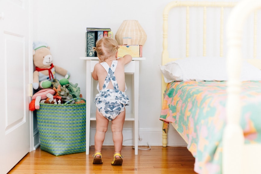 rear view of baby in bed room standing at table