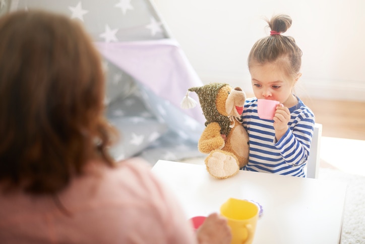 little girl drinking cofee with teddy bear