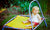 Little blonde girl sitting on a trampoline