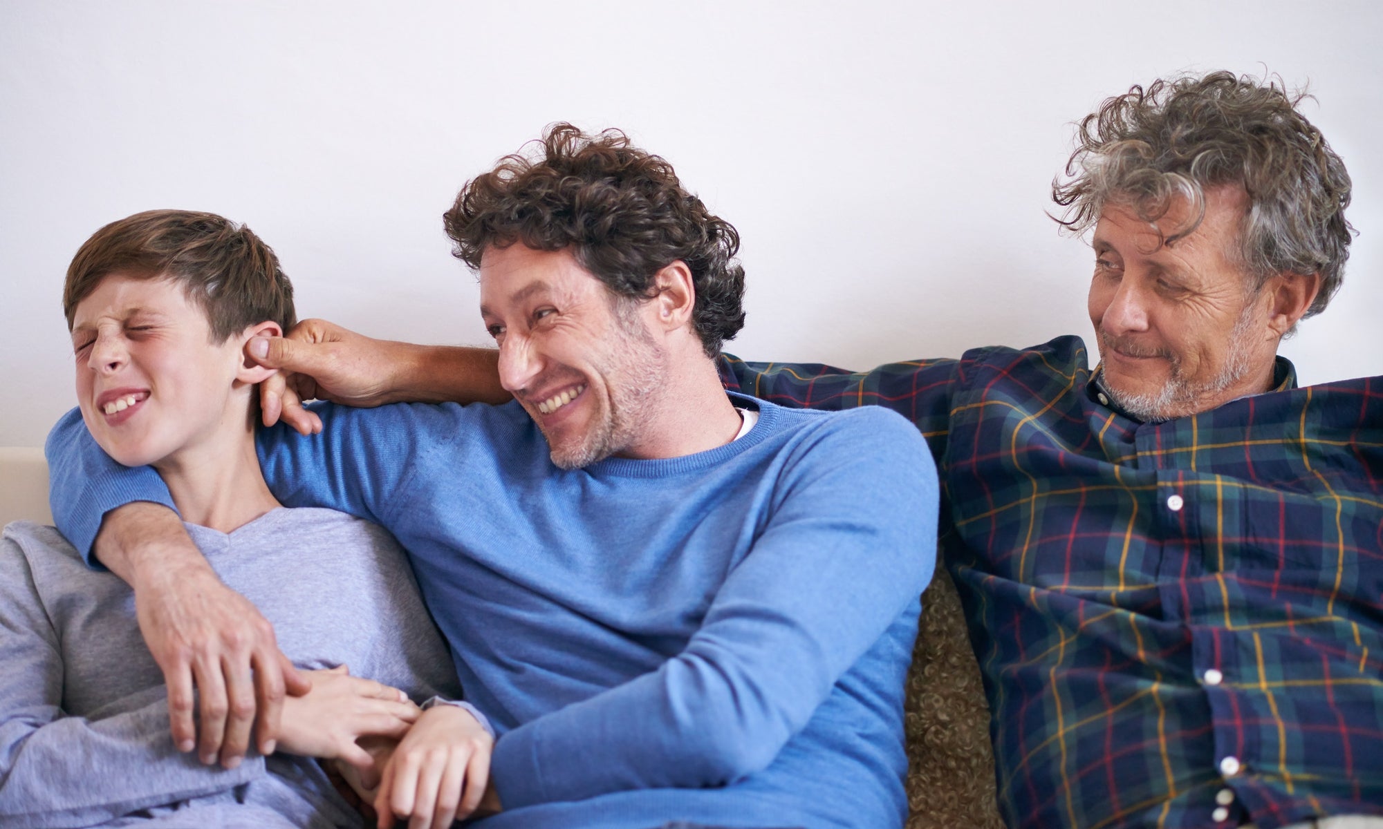 son, father and grandfather pulling grandson's ear