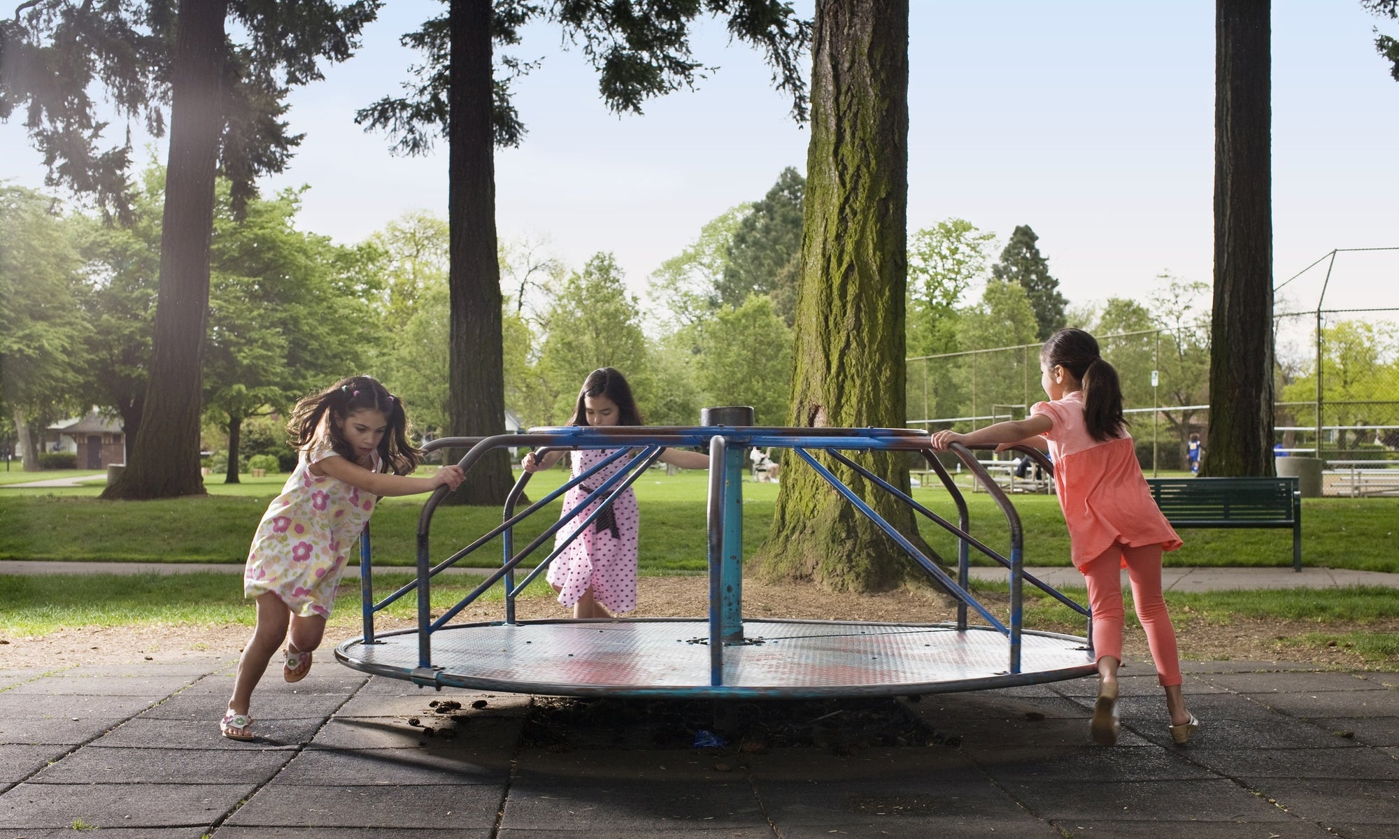 young girls playing on roundabout 