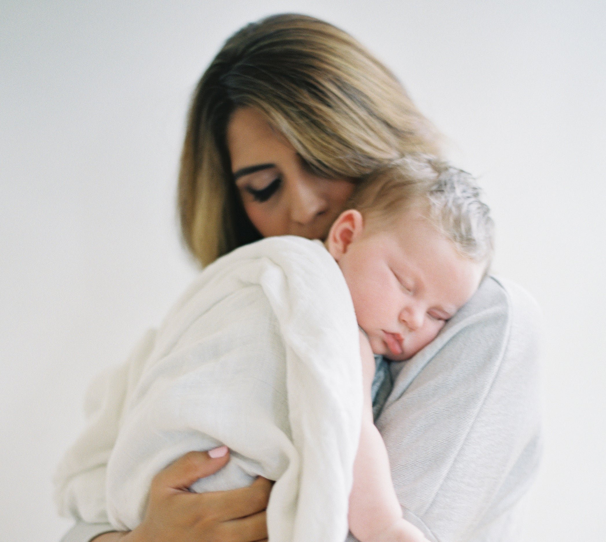 baby boy sleeping on mother's  shoulders