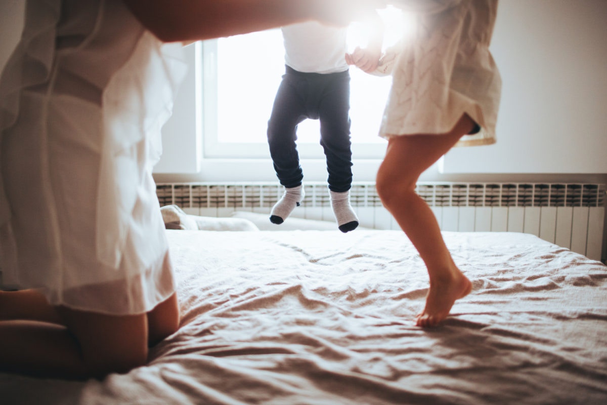 children legs jumping on bed