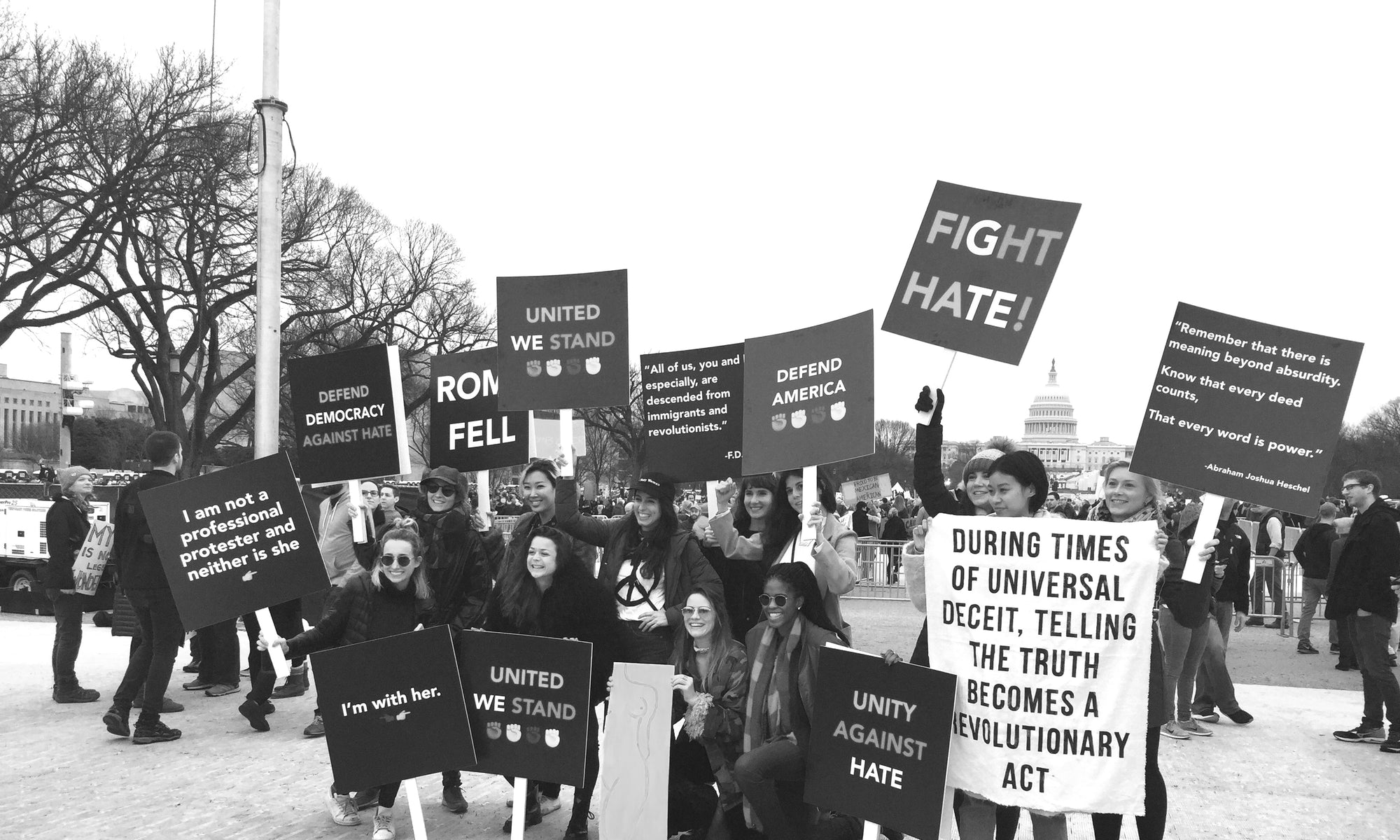 happy young girls holding posters near white house