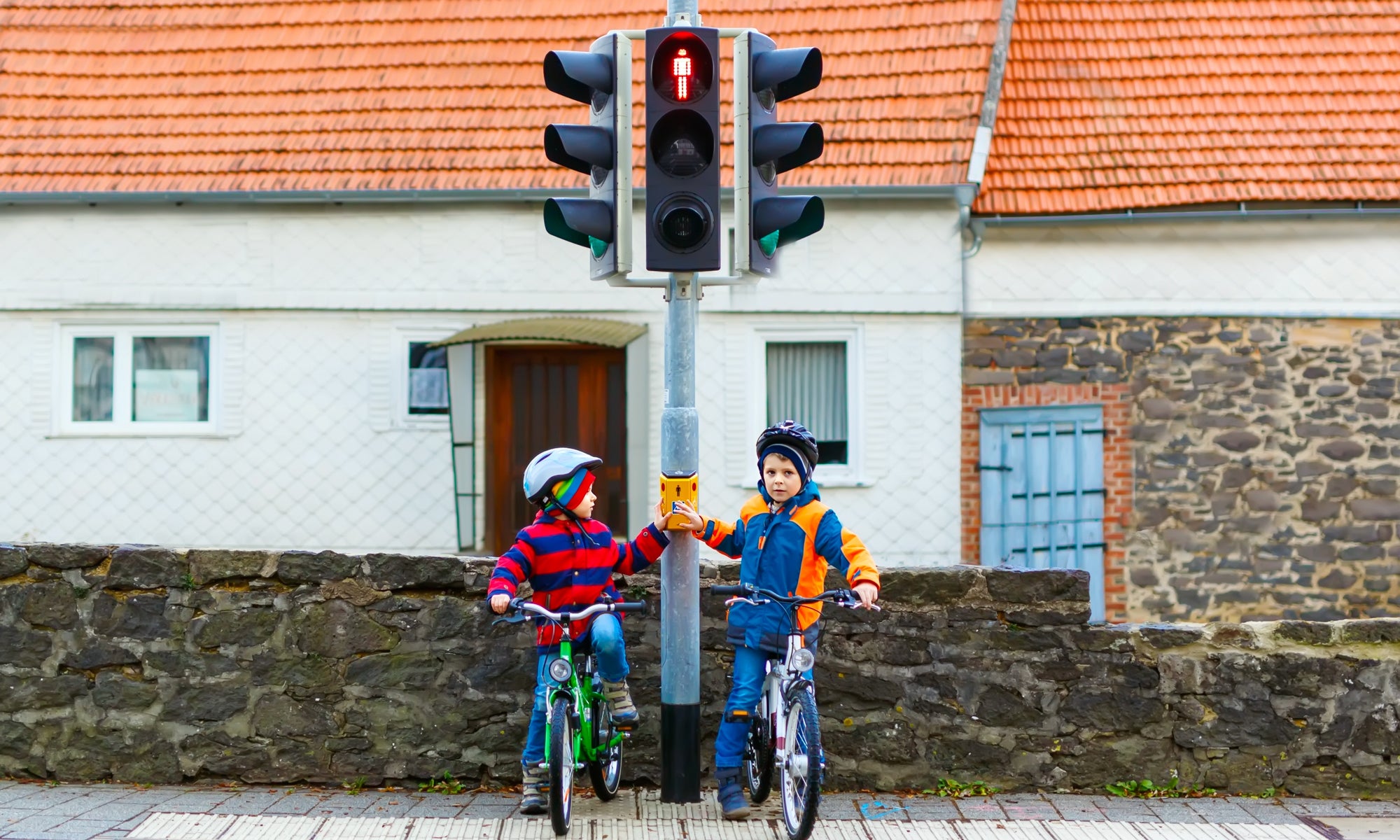 Two kids boys biking and waiting on traffic light