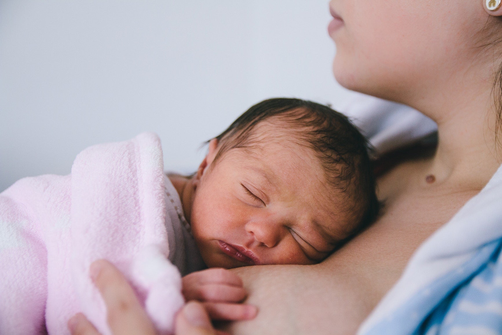 Newborn Baby Sleeping On Mother Chest