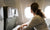 woman sitting on the seat looking out an airplane window while flying