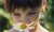 A little girl smelling flowers in a garden