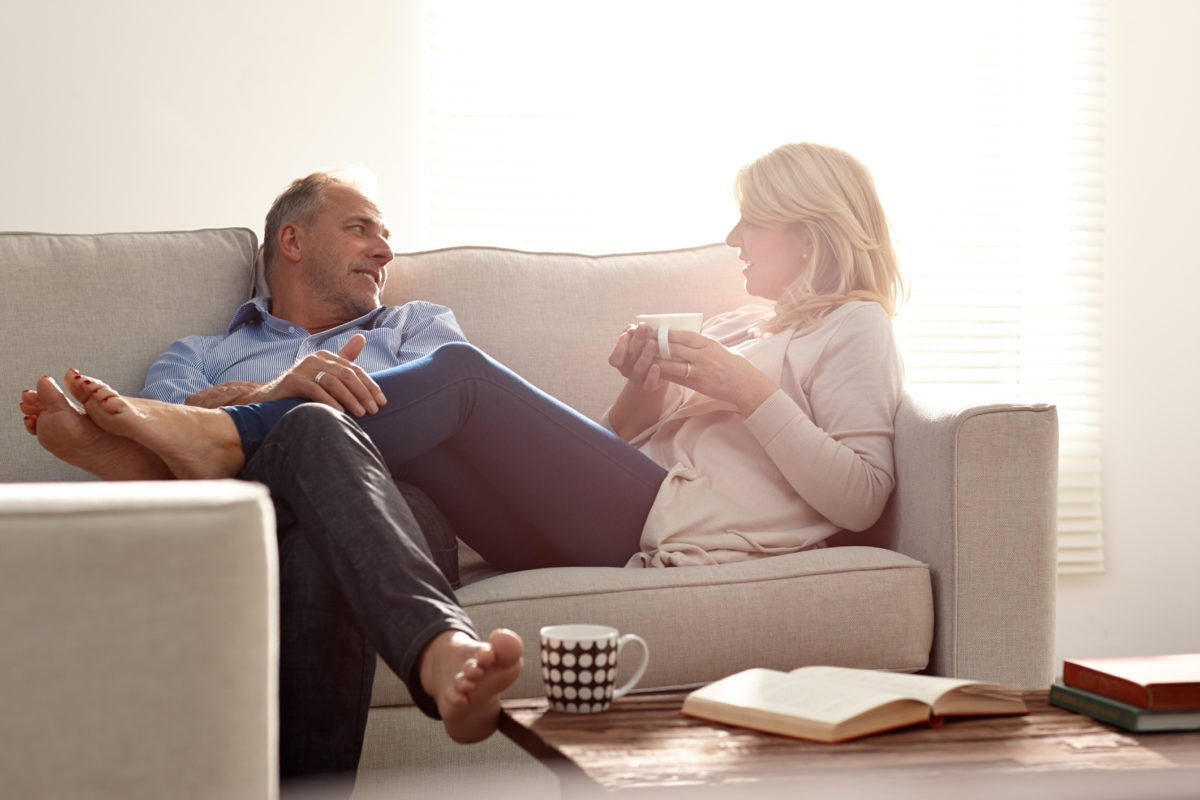 Couple on sofa, woman legs on man's lap