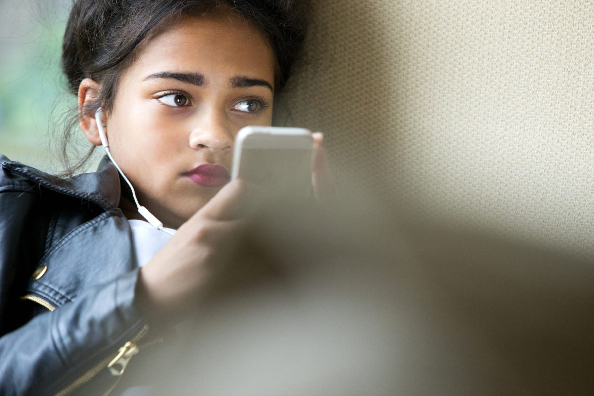 A girl wearing earphone and using phone