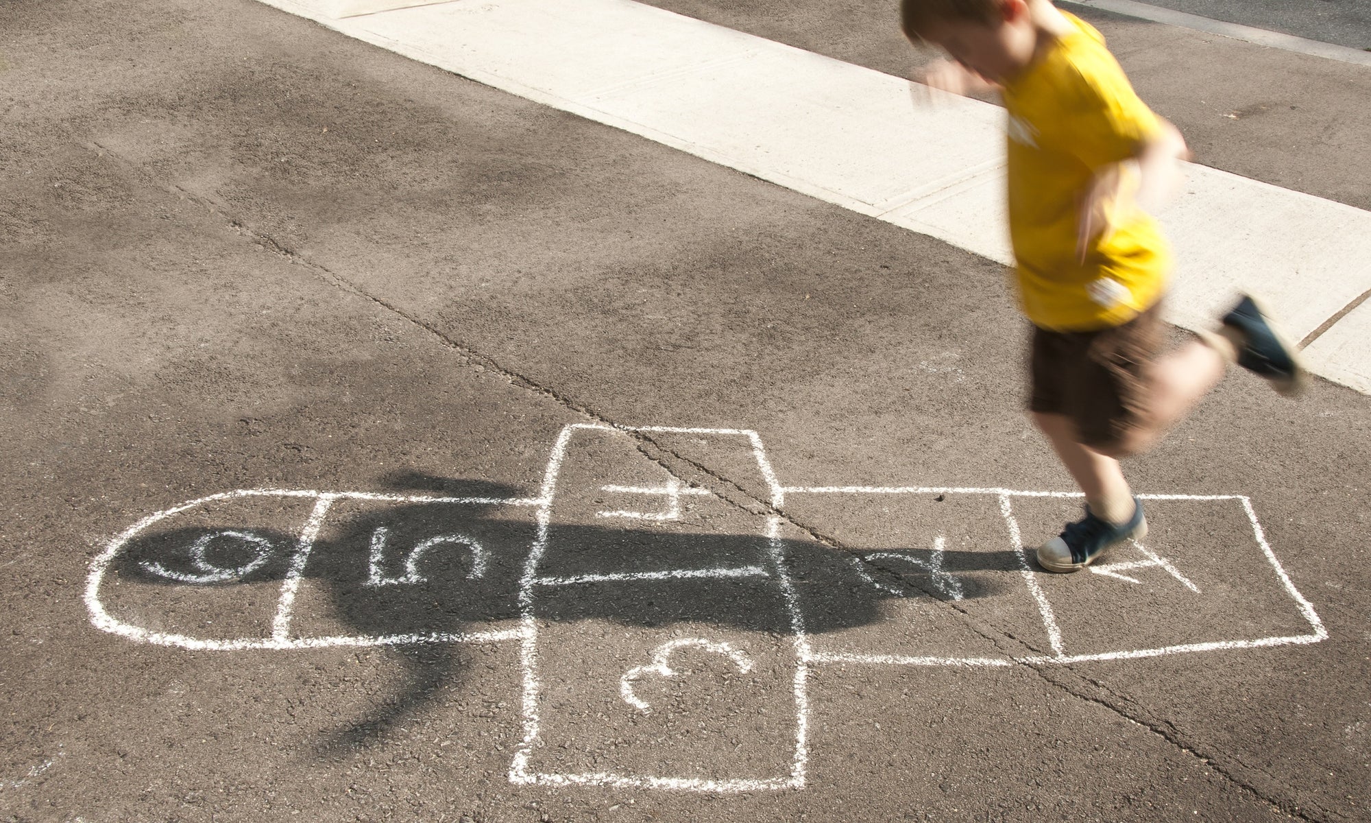 A boy is playing Hopscotch