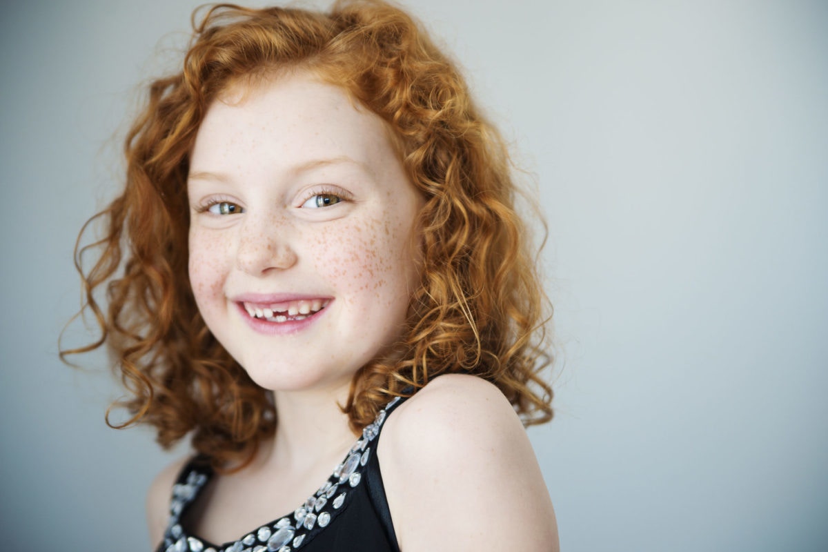 little girl with brown hair smiling