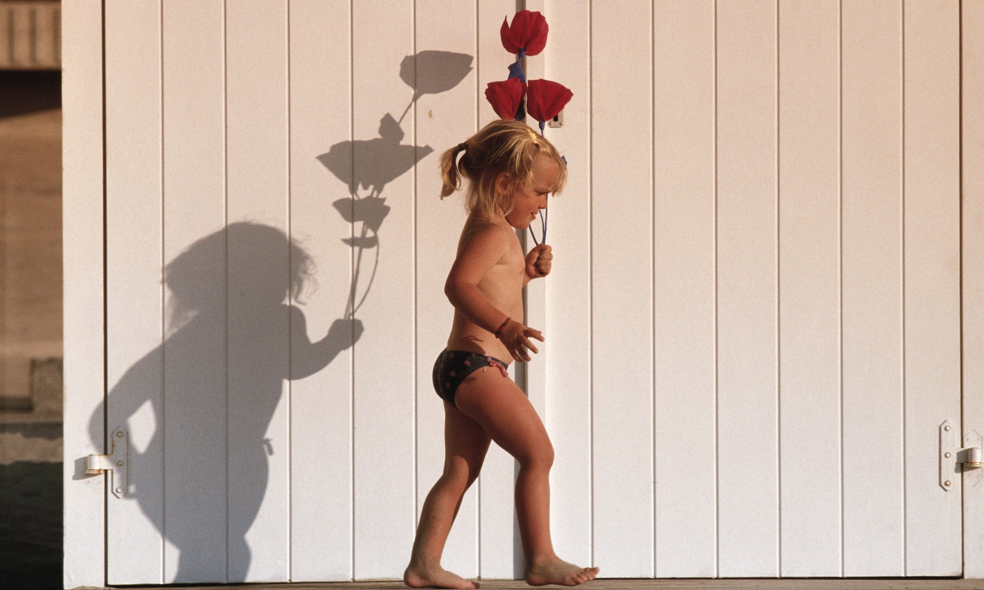 Girl walking with flowers outdoors, side view