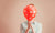 young girl covering face with balloon