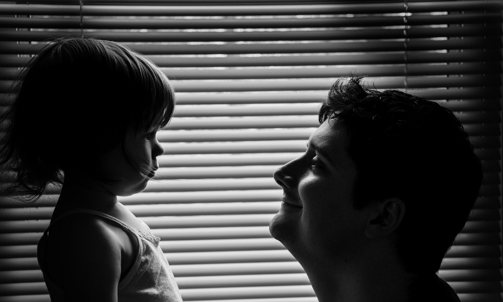 smiling father holding his little daughter