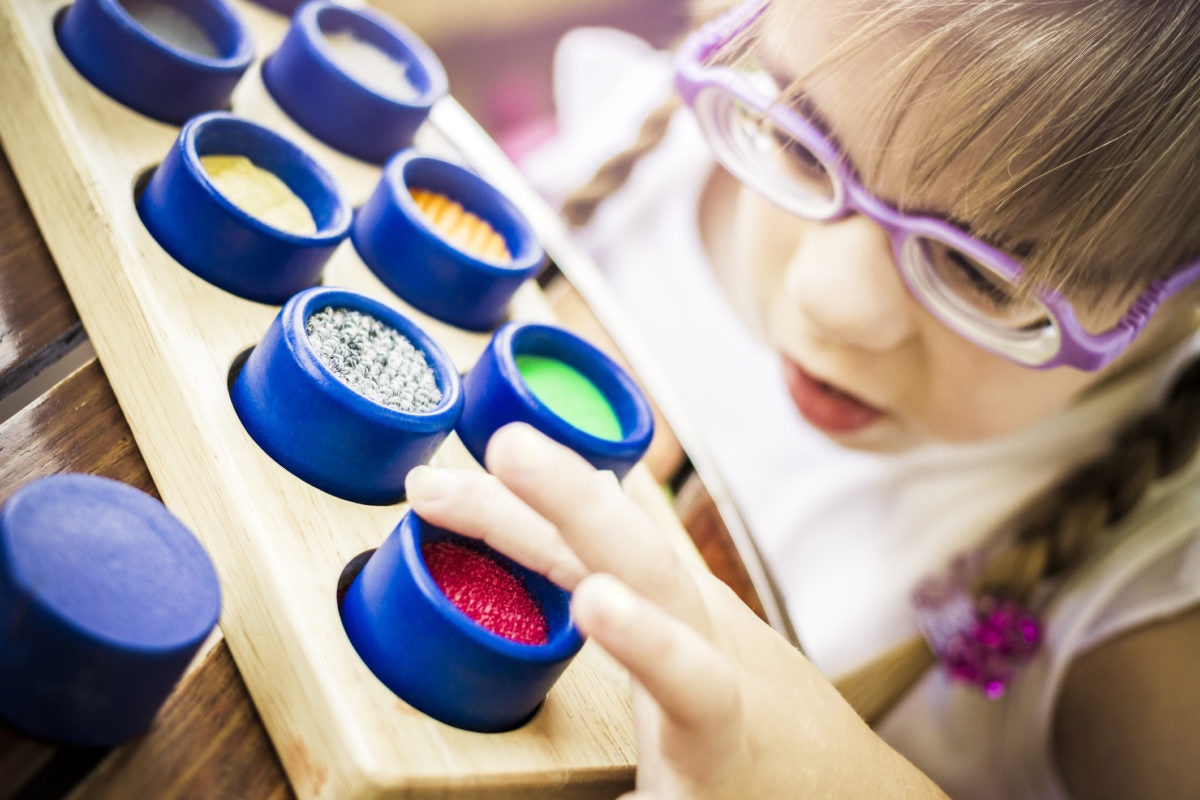 child touching textured cups