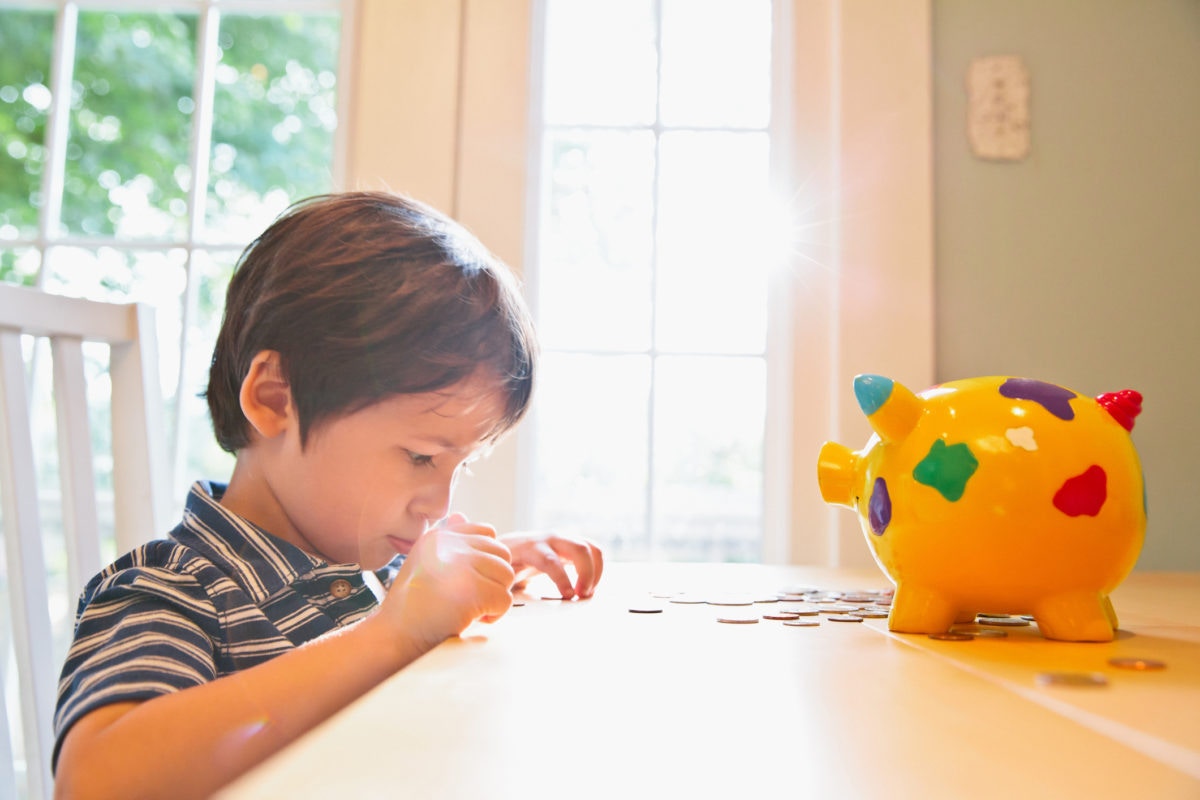 young boy counting his piggy bank money 