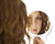A closeup mirror reflection of a woman's face
