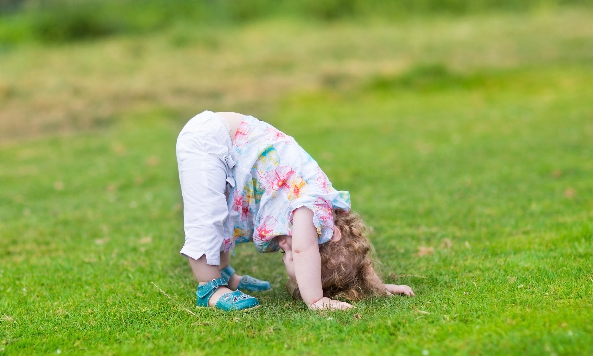 A kid is playing outside with head down