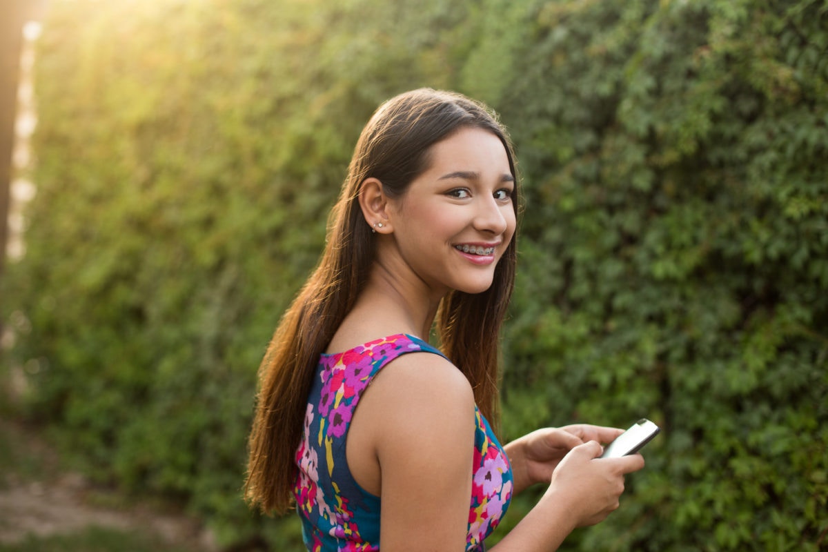 young girl with braces looking at camera smiling