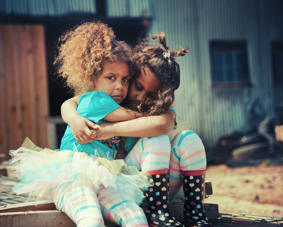 elder sister hugging tensed yonger sister