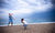 two young girls play along the sea