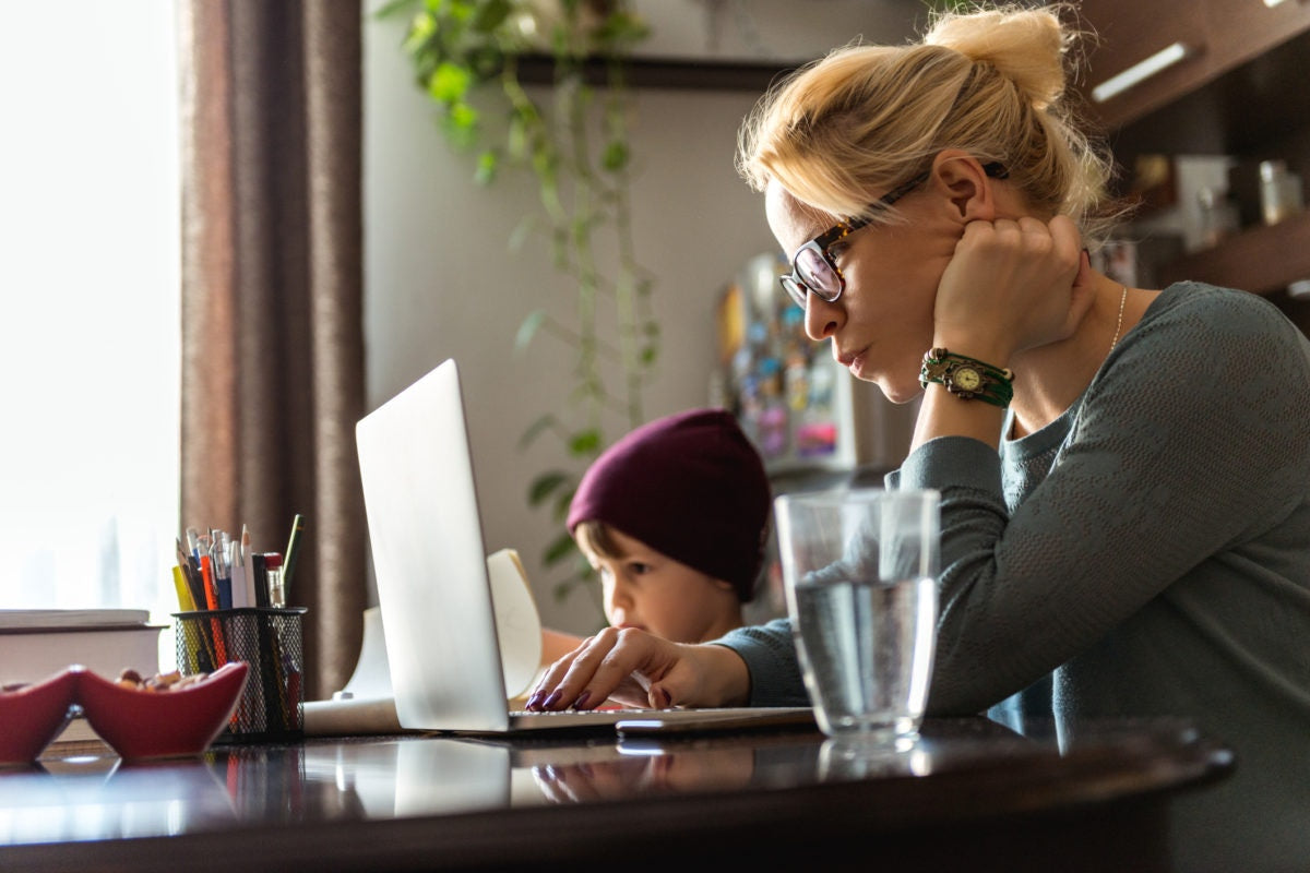 Mother working at home with son