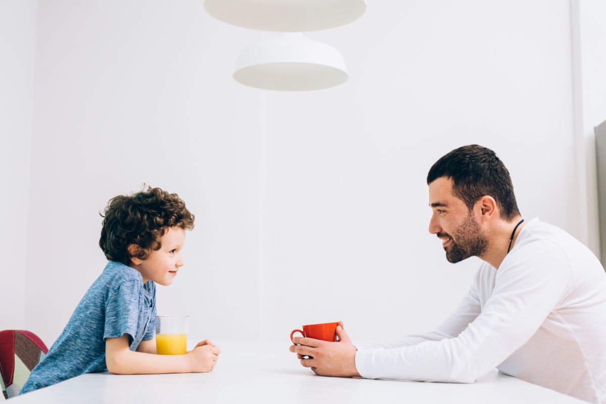 Father and son chatting at dining table