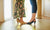 Little girl wearing heels with her mother in room