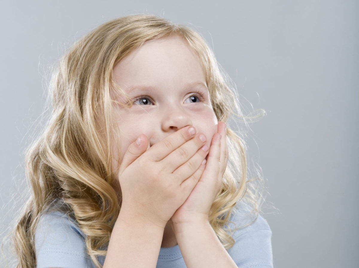 Young blonde girl laughing and embarrassed giggle covering mouth with hands