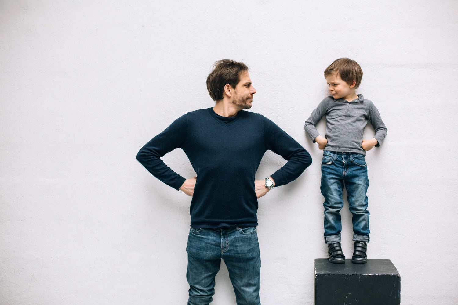 A child standing on a table beside his father