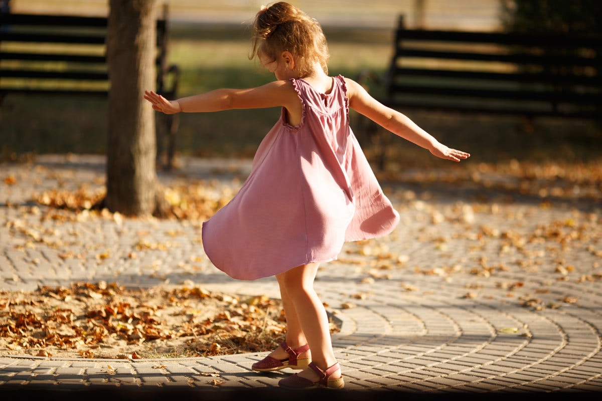 little girl with opened arms in the park