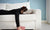 Woman lying in couch with face buried in pillow  and a book in her hand