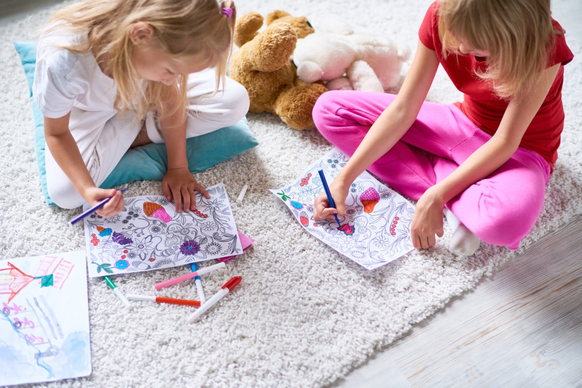 two girls drawing on the floor