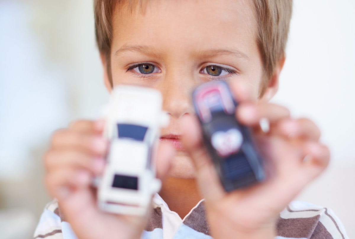 boy holding two toy cars