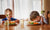 two kids not happy eating their vegetables