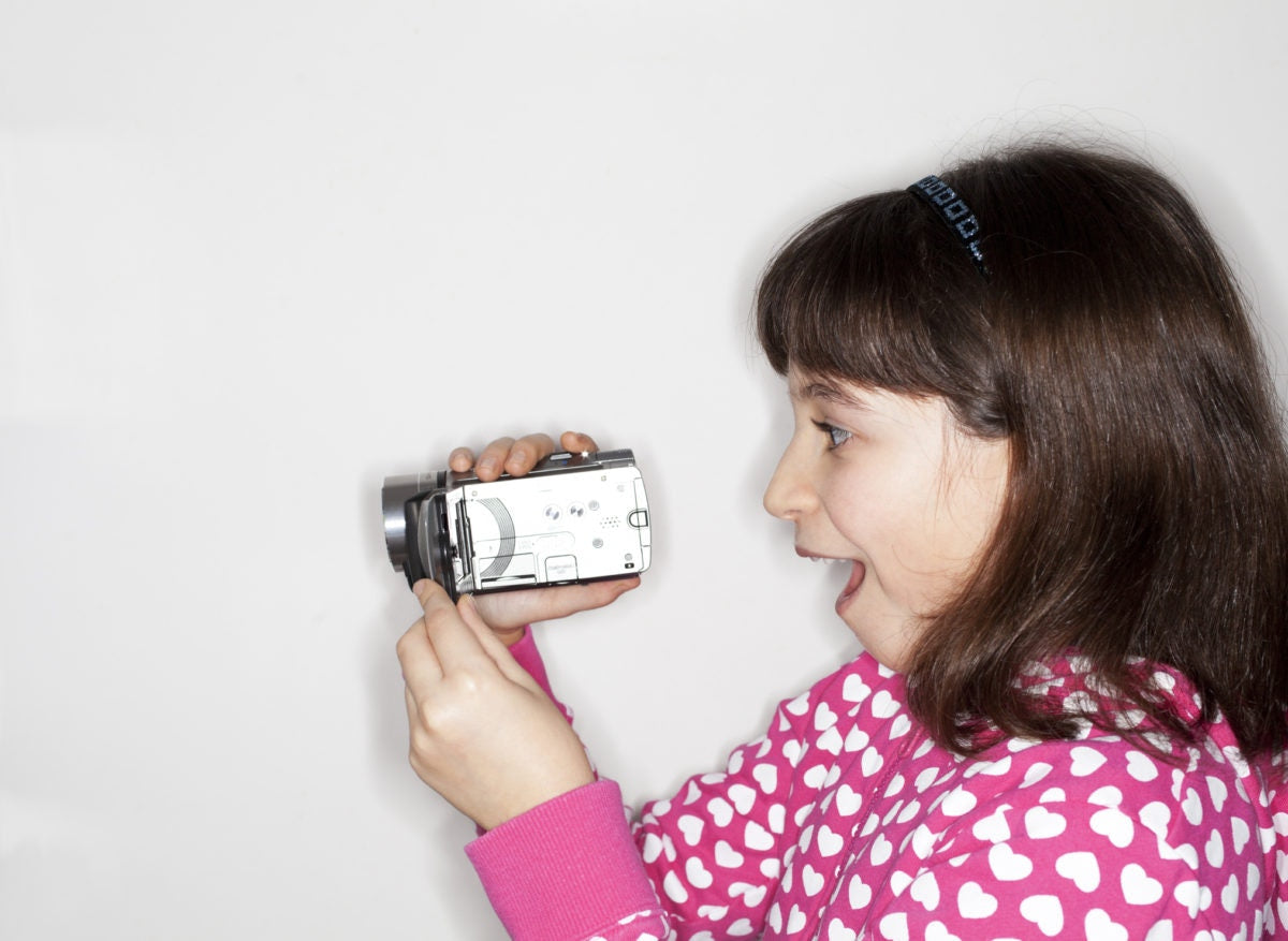 girl recording video at home with digital camera