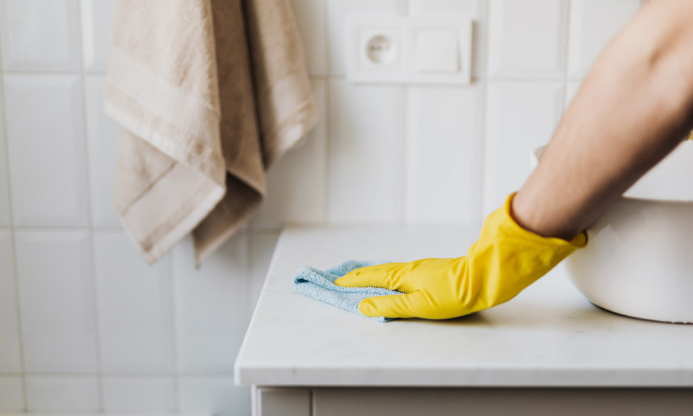 gloved hand cleaning countertop